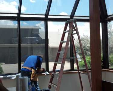 Installing Sunglo's Window Film using ladders in a office